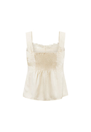 An off-white sleeveless smocked top with wide shoulder straps and a ruffled neckline, shown against a plain white background.