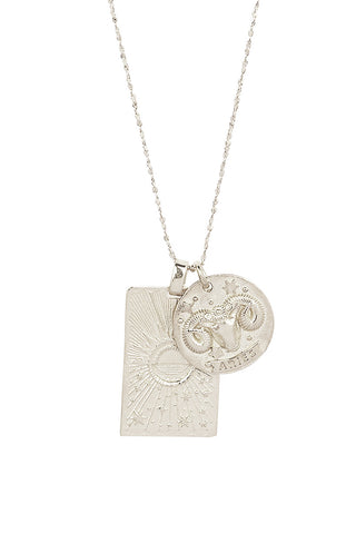close-up-front-view-of-spell-s-aries-stargazer-zodiac-necklace-charms-one-charm-is-of-a-rectangular-shape-and-features-a-sun-with-stars-while-the-other-charm-is-circular-and-features-the-zodiac-label-and-icon
